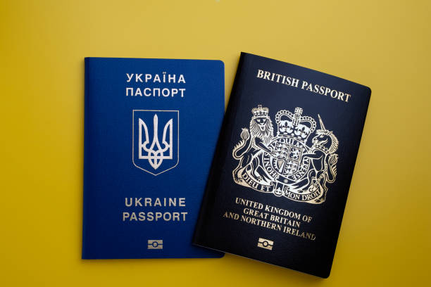 Ukrainian and British Passports placed on yellow background. stock photo