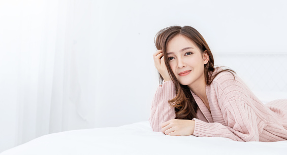 Portrait young beautiful asian woman relax in bedroom. Smile happy asian teenage girl with clear perfect japanese korean makeup skin isolated on white background. Cold winter lifestyle concept.