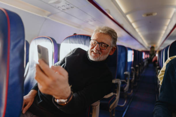 istock Senior man using a phone on board the aircraft 1388641928