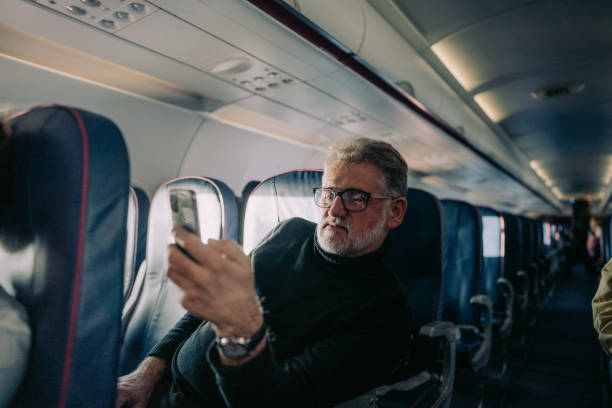 istock Senior man using a phone on board the aircraft 1388641950