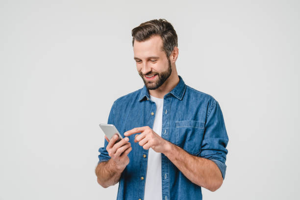 Happy caucasian young man using smart phone cellphone for calls, social media, mobile application online isolated in white background Happy caucasian young man using smart phone cellphone for calls, social media, mobile application online isolated in white background one person stock pictures, royalty-free photos & images