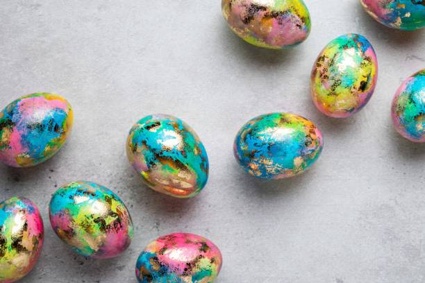 istock Happy Easter holiday greeting card with gold, blue, yellow, pink painted speckled easter eggs on grey background. Top view. 1388645025