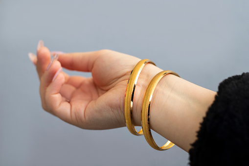 Graceful golden bracelets isolated on woman hand
