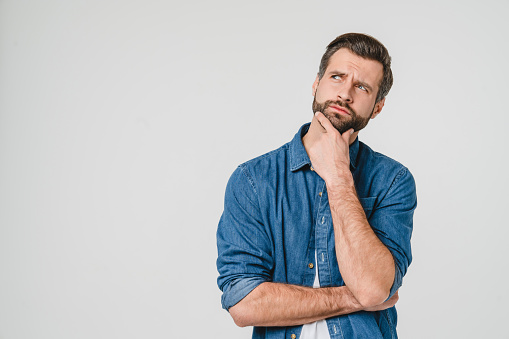 Pensive thoughtful contemplating caucasian young man thinking about future, planning new startup looking upwards isolated in white background