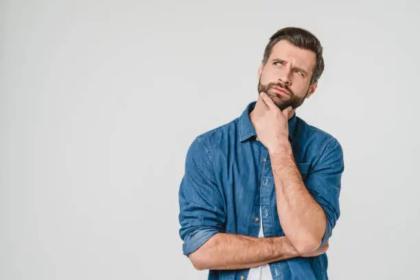 Pensive thoughtful contemplating caucasian young man thinking about future, planning new startup looking upwards isolated in white background