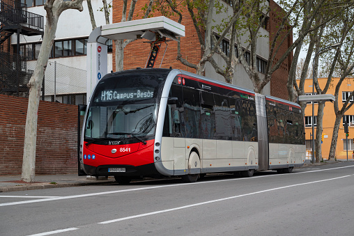 Barcelona, Spain - 28th March, 2022: Electric articulated bus Irizar ie tram on a charging point on a street. This model is developed in versions from 12m up to the 18m articulated version and with a maximum capacity of 155 people.