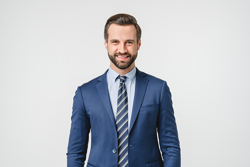 Portrait of handsome caucasian man in formal suit looking at camera smiling with toothy smile isolated in white background. Confident businessman ceo boss freelancer manager