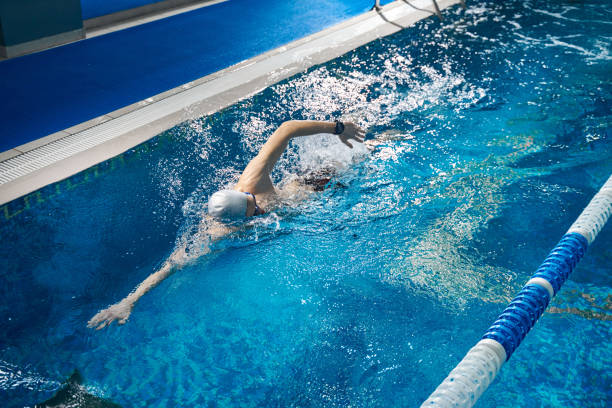 istock Athletic man swimming in pool, night workout 1388647257