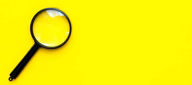 istock Black magnifier on a yellow  background. 1388648165