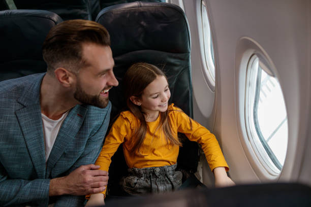 istock Happy father and daughter looking out airplane window 1388655150