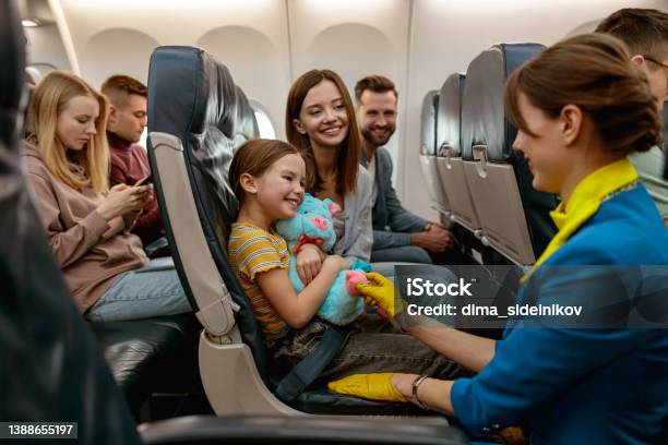 Family With Child Talking With Stewardess In Airplane Stock Photo - Download Image Now