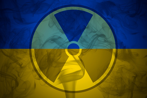 The risk of nuclear war and radiation pollution. Radiation sign on the background of flag of Ukraine