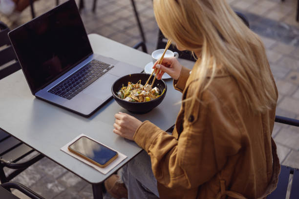 istock Woman on lunch break eating food outside using chopsticks 1388657037
