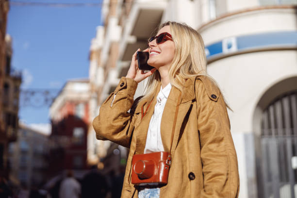 istock Yong lady calling someone while standing in street 1388657054