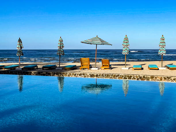 istock Beach umbrellas and chairs at the beach next to pool 1388663946