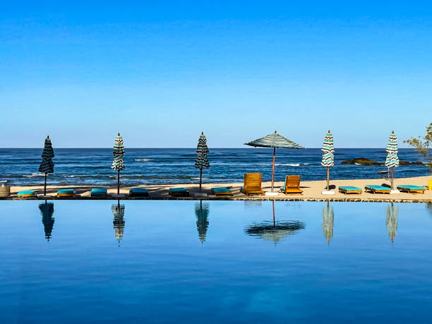 istock Beach umbrellas and chairs at the beach next to pool 1388663953