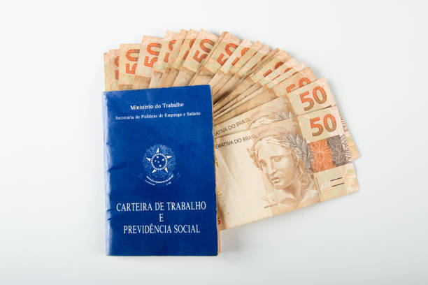 istock Brazilian document work and social security (Carteira de Trabalho e Previdencia Social) with Brazilian money banknotes 1388670807