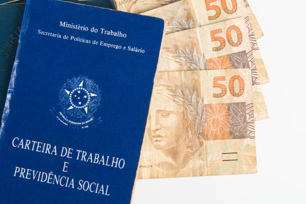 istock Brazilian document work and social security (Carteira de Trabalho e Previdencia Social) with Brazilian money banknotes 1388670818