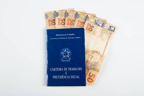 istock Brazilian document work and social security (Carteira de Trabalho e Previdencia Social) with Brazilian money banknotes 1388670825