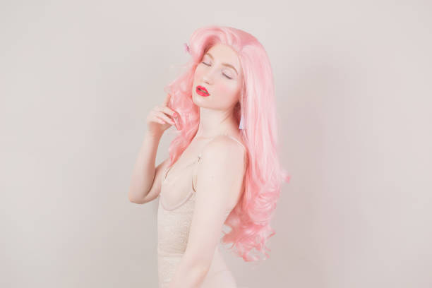 Pink hair woman in wig on pastel background. Beautiful sexy girl in long wavy wig. Minimal spring trend. Pastel color. Hair dye in salon. Lady with trendy hairstyle. Red lips Pink hair woman in wig on pastel background. Beautiful sexy girl in long wavy wig. Minimal spring trend. Pastel color. Hair dye in salon. Lady with trendy hairstyle. Red lips Comfortable Wig Alternatives stock pictures, royalty-free photos & images