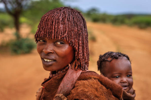 彼女の赤ちゃん�、エチオピア、アフリカを運ぶハマー部族からの女性 - hamer woman ストックフォトと画像