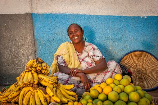 Portrait of Ethiopian woman selling fruits on Harar's market, Ethiopia, Africa. Harar Jugol, the old walled city, is listed as a World Heritage Site by UNESCO. Harar also is considered the fourth holiest city of Islam with 82 mosques.
