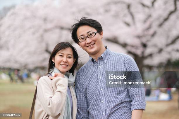咲き誇る桜の木を背景にしたカップルの肖像画