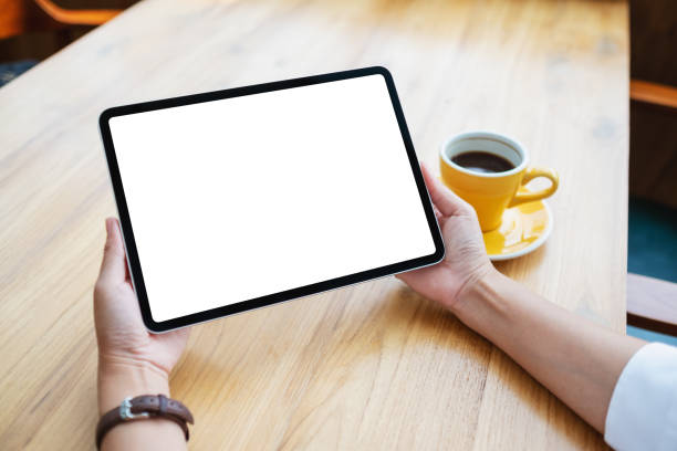 istock Mockup image of a woman holding digital tablet with blank white desktop screen 1388692980