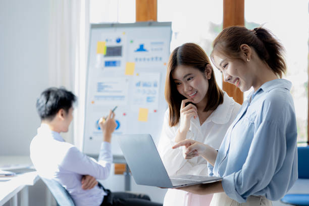 istock Two Asian women are working together, consulting and brainstorming to analyze data to devise marketing plans for growth companies, start-up executives and employees. Management startup company. 1388693983