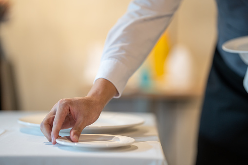 A waiter setting table in a restaurant