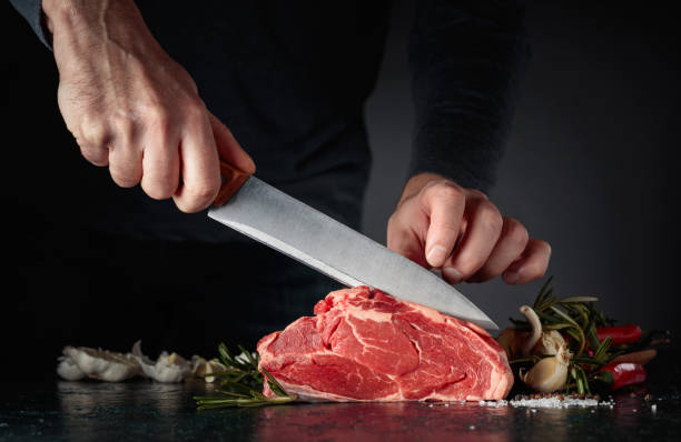 Chef cutting raw beef meat. stock photo