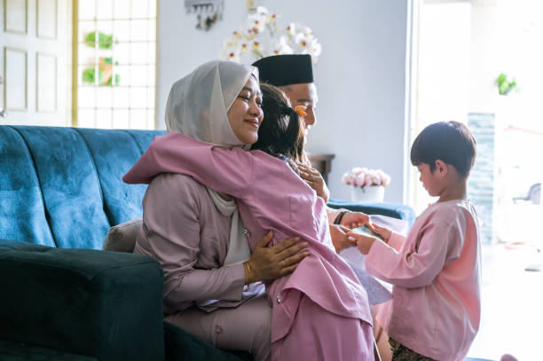 familia musulmana malaya abraza durante la celebración de hari raya puasa - típico oriental fotografías e imágenes de stock