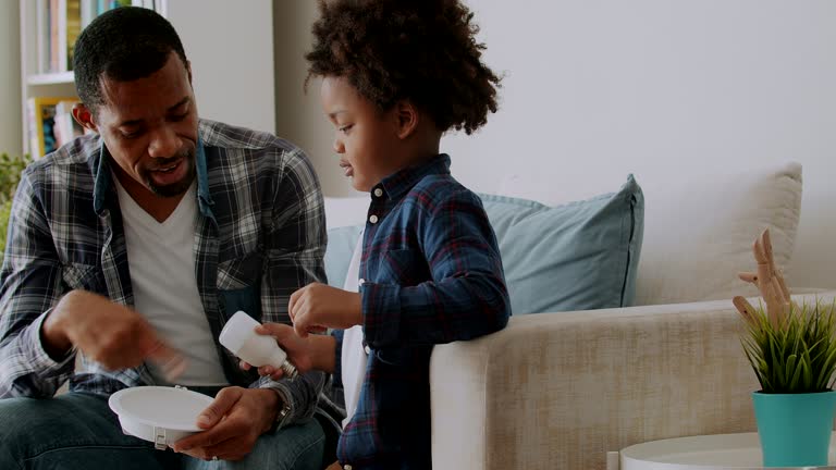 Close up of father teaching his son on energy efficient lightbulb.