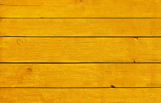 Close up background texture of warm yellow vintage weathered painted wooden planks, rustic style wall panel