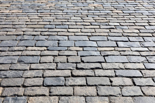 istock Stone pavement texture, cobbled street in sunlight 1388711702