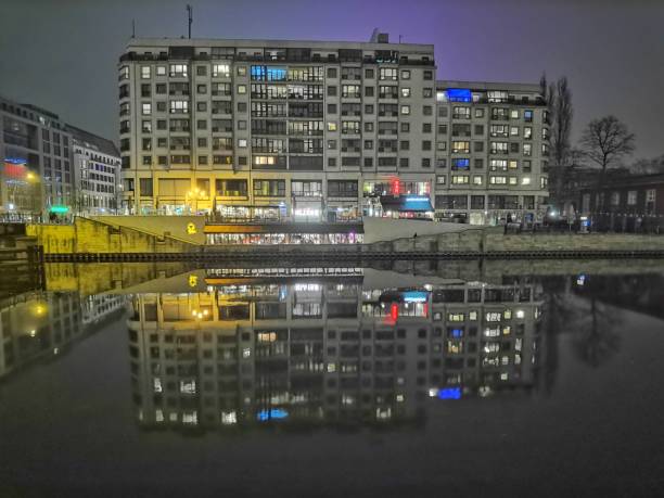 February 27, 2022 - Berlin, Germany: Promenade with restaurants reflected at spree river in Berlin at night, Germany