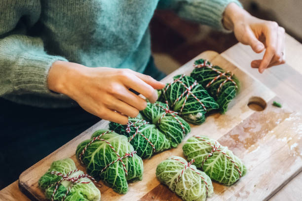 preparing vegan cabbage rolls on wooden kitchen board