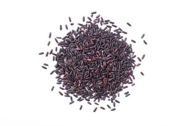 black rice isolated on white Pile of black rice isolated on white background. Top view. Flat lay. jasmine rice stock pictures, royalty-free photos & images