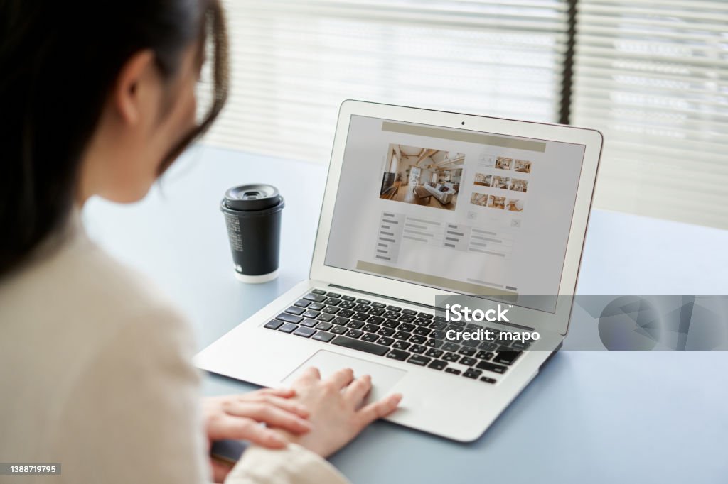 Asian women viewing real estate websites on a computer Web Page Stock Photo