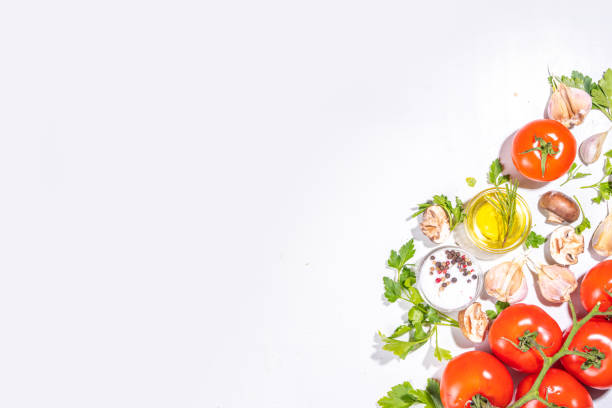 Food cooking preparation background. Kitchen table background with spices, herbs, vegetables. Parsley, onion, garlic, tomatoes, salt, olive oil on a white background top view flatlay copy space