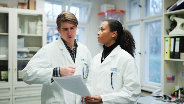Scientist discussing latest findings with male colleague in laboratory