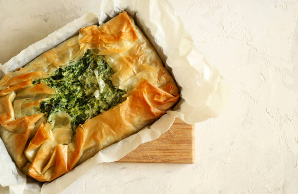 Greek Spanakopita pie. Traditional greek cuisine. Homemade Spanakopita, phyllo pastry pie with spinach and feta cheese on white background. Directly above. filo pastry stock pictures, royalty-free photos & images