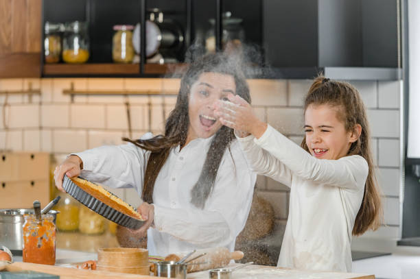 istock Mother and little daughter baking together in a home kitchen making a pie 1388733528