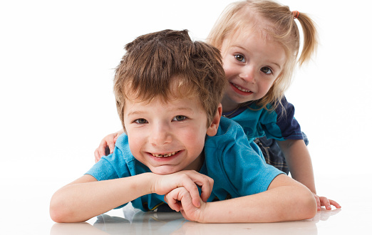 Portrait of a brother and sister, curly blond with blue eyes laughing merrily on a white background. Children's emotions, happiness, joy, fun. Beautiful cute children. Friendship. High quality photo