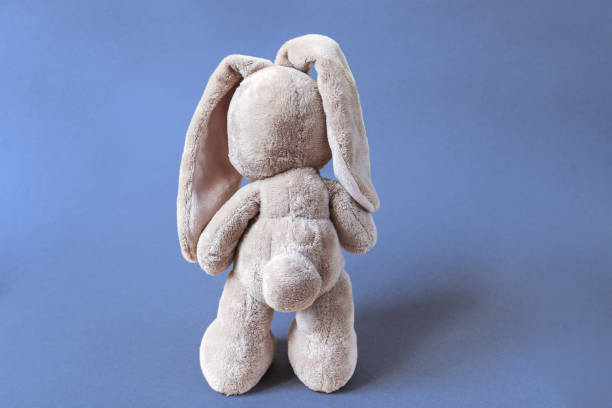 istock soft toy hare stands facing away on a bright blue background 1388737236