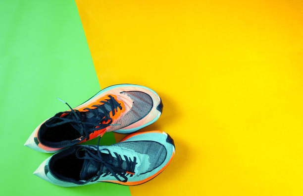istock Blue and orange running shoe on green floor with copy test space,top 1388737301