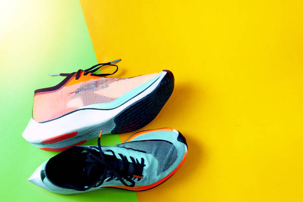 istock Blue and orange running shoes on color floor 1388737302