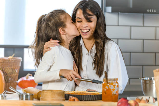 istock Mother and little daughter baking together in a home kitchen making a pie 1388737614