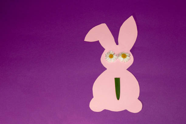 istock pink paper bunny with daisy eyes and grass tie, creative art srping concept, easter design 1388740865