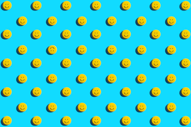 Yellow smiley face cookie, food, flat lay, top view, copy space on blue background. Be different.